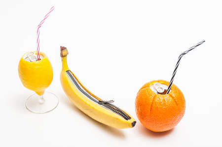 A lemon and an orange  with soda can opener and a banana with zipper on a white backgroundの写真素材