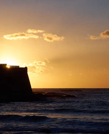 The sun drops behind the old fortress of Algajola in Corsica