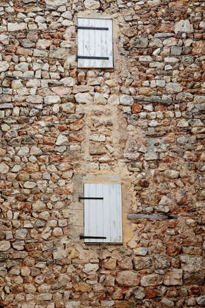 Stone wall with closed windowsの写真素材
