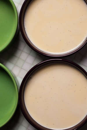 Creme brulee before baking - custard yellow cream in porcelain ramekinsの写真素材