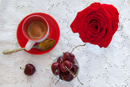 Romantic breakfast on a summer terrace; coffee, cherries and red  rose.の写真素材