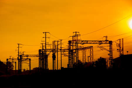 Silhouette High speed railway power line in perspective on spectacular intense orange sky, sunset or...