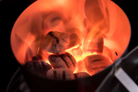 Charcoal Briquettes for barbecue lights up in Chimney Starter