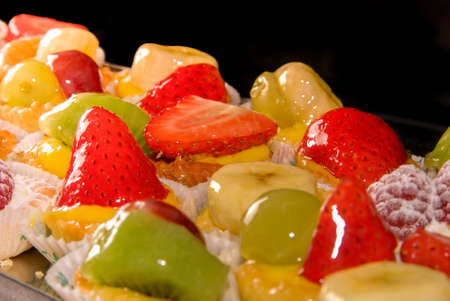 tray with assortment of Italian pastries with fruit banana grape raspberry kiwi and fruit jelly....