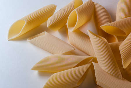 Italian dry raw pasta penne rigate macaroni, bronze die on white background top viewの写真素材