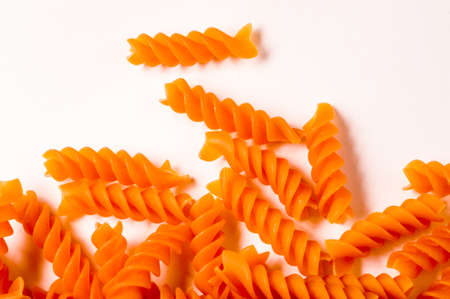 Italian dry raw pasta. colored wheels, macaroni, bronze die on white background top view