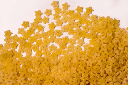 Italian dry raw pasta little star, bronze die on white background top viewの写真素材