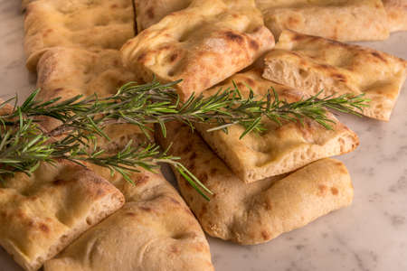Italian bread of Focaccia Genoese sliced in squared pieces, white pizza whit fresh rosemary on a...