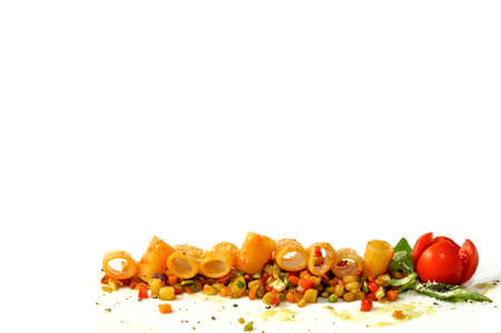 mezze manic pasta with tomato sauce on cooked cut vegetables with cherry tomato and basil leaves isolated on white background at the base of the frame, copy spaceの写真素材