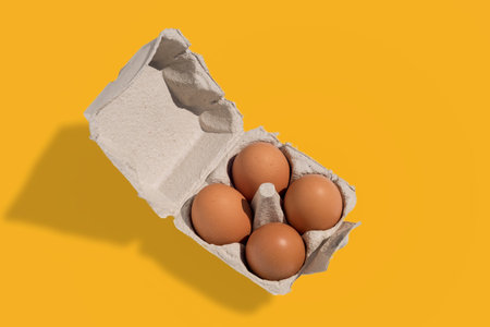 Egg box with eggs, four chicken eggs in cardboard egg tray made from recycled paper isolated on...