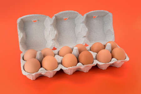 Egg box with chicken eggs, a dozen eggs in cardboard egg tray made from recycled paper isolated on...