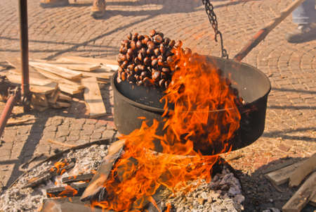 Roasted Chesnut, italian Caldarroste, jump on the flames at the Marrone Chestnut Fair in Cuneo, Piedmont, Italyの写真素材