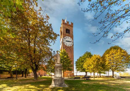 MondovÃ¬, Cuneo, Piedmont, Italy - October 23, 2021: Belvedere Gardens with the Civic Tower, called "dei Bressani" or Clock Tower, and trees with Autumn colorsのeditorial素材
