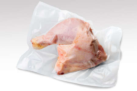 Whole chicken thigh in vacuum packed sealed for sous vide cooking isolated on white backgroundの写真素材