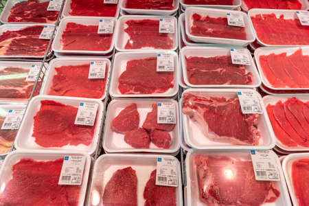 Fossano, Italy - October 24, 2021: different types of cuts of beef steaks packaged in plastic food trays displayed in the refrigerated counter of an Italian supermarketのeditorial素材