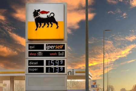 Fossano, Italy - December 23, 2021: Eni logo sign with fuel price display on sunset sky, Eni Spa is an Italian oil company worldwide. Expensive fuel price concept.のeditorial素材