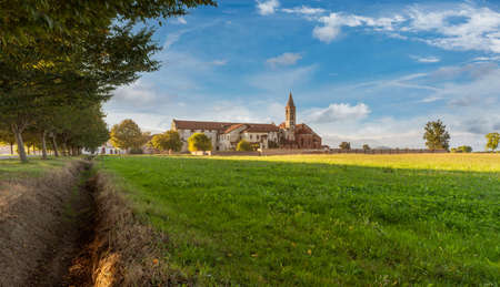 Staffarda di Revello, Saluzzo, Italy - October 8, 2021: Abbey of Santa Maria di Staffarda of Roman Gothic style (XII century) between green meadows and blue skyのeditorial素材