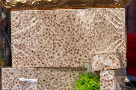 Large piece of nougat with Piedmont IGP hazelnuts from Langhe, round and gentle, on a stand for sale sweetsの写真素材