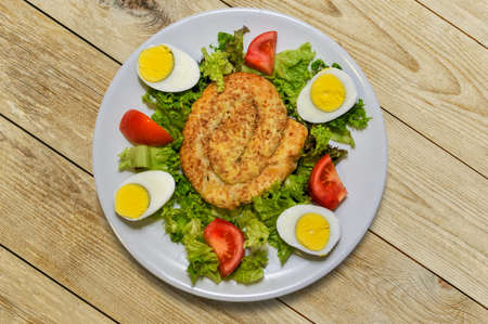 Burek: Traditional recipe of Turkish and Balkan cuisine in white dish with boiled eggs, lettuce and tomatoes. Top View on wooden tableの写真素材
