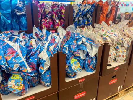 Italy - February 22, 2022: Colorful packs of Easter chocolate eggs in Italian supermarket shelvesのeditorial素材