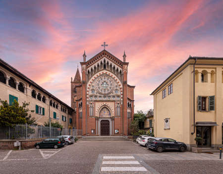 Cavallermaggiore, Italy - March 12, 2022: Church of Santa Maria della Pieve in eclectic gothic style (early 1900s), in via Roma, with sunset skyのeditorial素材
