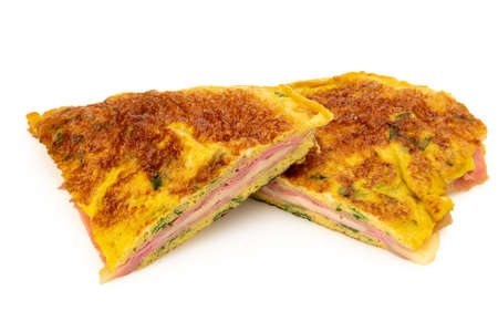Omelette with herbs stuffed with ham and cheese isolated on whiteの写真素材