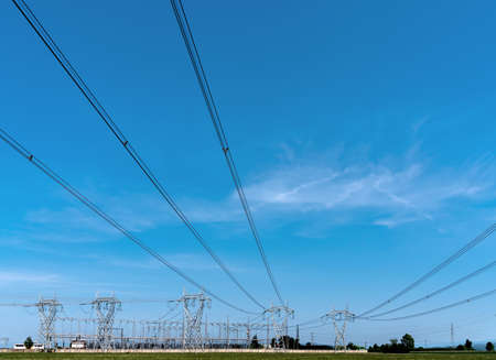 High-voltage power lines, high voltage electric transmission towers on blue sky, copy space