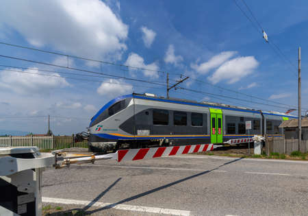 Centallo, Cuneo, Italy - May 13, 2022: closed level crossing with the passage of the Trenitalia...