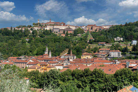 MondovÃ¬, Cuneo, Italy: cityscape with below the Breo district and on the MondovÃ¬ hill Piazza with the clock tower and green parks with blue sky with white cloudsの写真素材