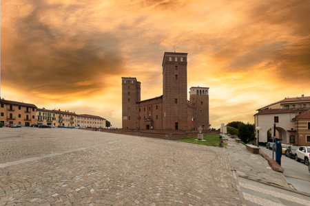Fossano, Cuneo, Italy - September 3, 2022: The Castle of the Princes of Acaja (XIV century) in Castle square cobblestone with colorful sunset skyのeditorial素材