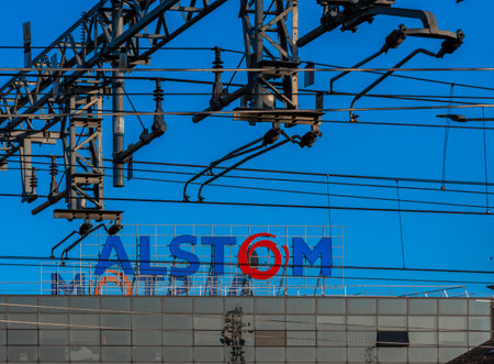 Savigliano; Wedge; Italy - February 16; 2023: ALSTOM sign on the Savigliano factory; foreground railway power cables. ALSTOM is the world's leading factory producing trains and high-speed trainのeditorial素材