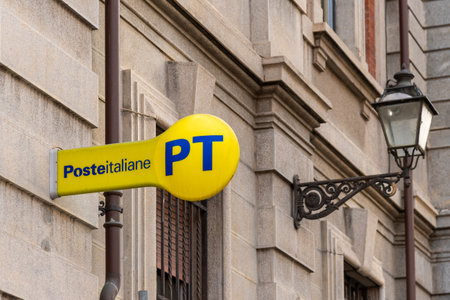 Cuneo, Italy - April 11, 2022: PT Poste Italiane, Italy Post logo on yellow sign near ancient lamppost , outside the Italian post office. Tex: Posteitaliane (Italian Post)のeditorial素材