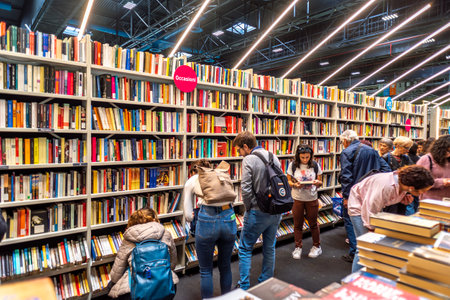 Turin, Italy - May 22, 2023: visitors in front of shelves with cheap second-hand books on shelves at the 35th Turin International Book Fair.のeditorial素材