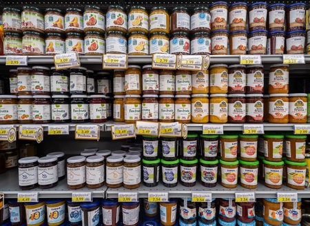 Italy - May 25, 2023: different kinds of organic jam and 100% fruit jam in glass jars on shelf for sale in Italian supermarket. tex: organic productのeditorial素材