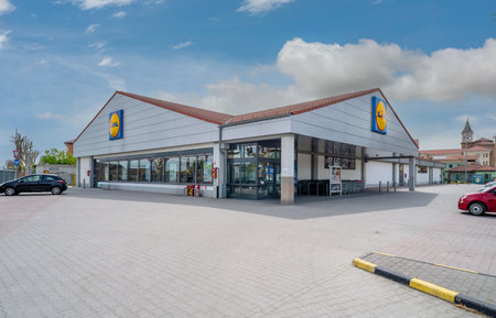 Racconigi, Italy - April 27, 2023: exterior of LIDL discount store on blue sky with clouds. Lidl is a German global discount supermarket chain.のeditorial素材