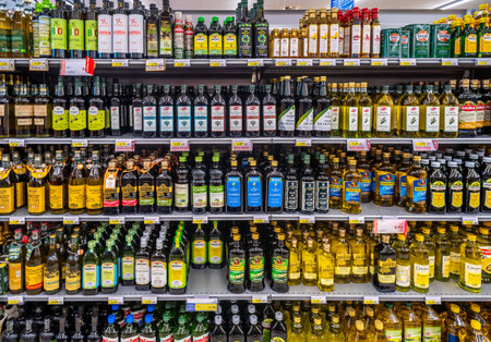Italy - May 31, 2023: olive oil in glass bottles of various brands and types on shelves for sale in an Italian supermarketのeditorial素材