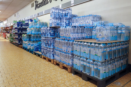 Italy - November 09, 2023: Mineral water in plastic bottles packaged and stacked on pallets for sale in the aisle of Italian discount store LIDLのeditorial素材