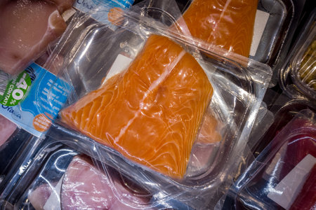 Italy-November 11, 2023: Salmon slice in vacuum-sealed trays for sous vide cooking for sale in supermarket refrigerated countersのeditorial素材
