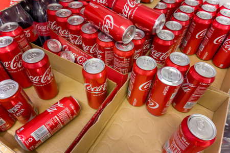 Italy - November 26, 2023: Coca Cola cans in cardboard boxes for sale in Italian discount store
