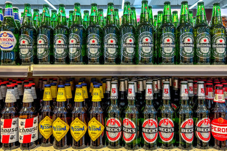 Italy - January 11, 2024: Beer in glass bottles of various types and brands displayed on shelves for sale in Italian supermarket. Heineken pure malte lager and becks beer and Messina Beer.のeditorial素材