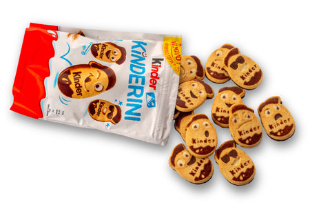 Italy - January 20, 2024: Ferrero Kinder milk and cocoa shortbread cookies in shape of little faces in different expressions, package with cookies scattered isolated on whiteのeditorial素材