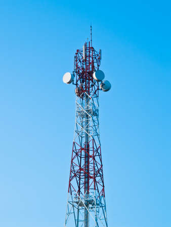 Mobile phone communication repeater antenna tower in blue skyの写真素材
