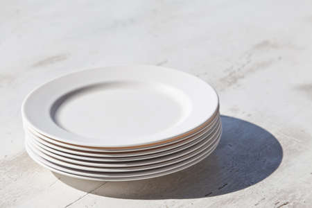 Stack of plates and shadow, on dining tableの写真素材