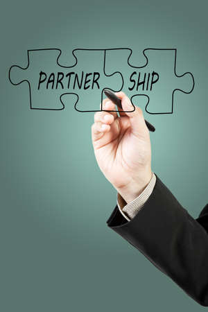 Businessman drawing partnership puzzle pieces
