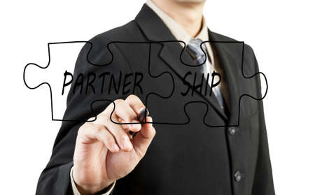 Businessman drawing partnership puzzle piecesの写真素材