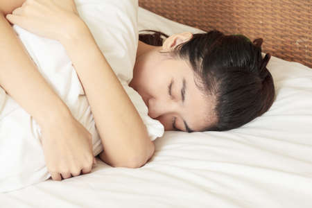 young beautiful woman sleeping in bedの写真素材