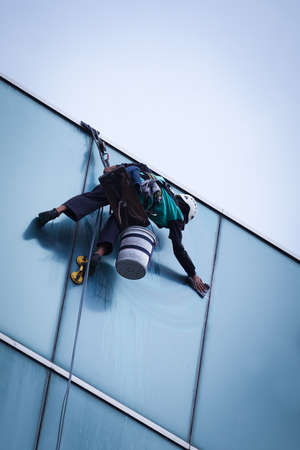 worker cleaning windows service on high rise buildingの写真素材