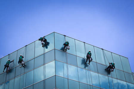 group of workers cleaning windows service on high rise buildingの写真素材