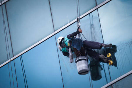 group of workers cleaning windows service on high rise buildingの写真素材