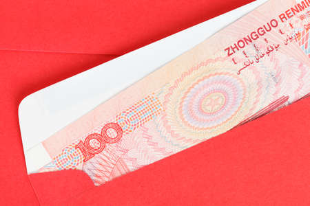 Chinese or 100 Yuan banknotes money in red envelope, as chinese new year backgroundの写真素材